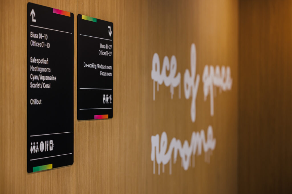 Aranżacja biura Ace of Space Wrocław Renoma- oznakowanie na drewnianej ścianie